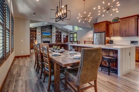 - Dining room with large rustic table and seating
- Overlooks kitchen and living area with fireplace
- Open-concept design for family meals and gatherings