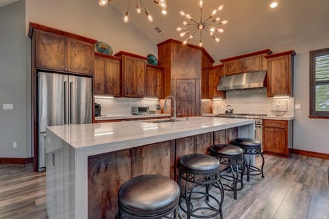 - Kitchen with marble island and modern lighting
- Stainless steel appliances and rich wood cabinets
- Open layout ideal for cooking and gathering