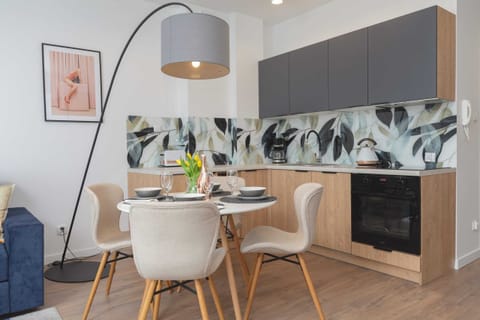 Dining space with a table set for meals and a view of the adjoining kitchenette. Fresh flowers add a welcoming touch.