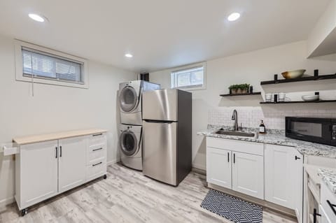Utility room with washer and dryer, sink and second refrigerator.