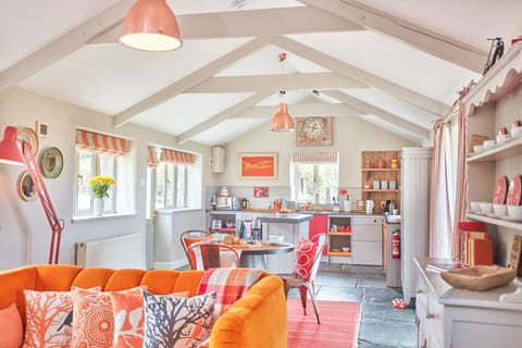 Meadow View, Newquay. Sitting room area with a plush velvet sofa, Smart television, wood burning stove and patio doors