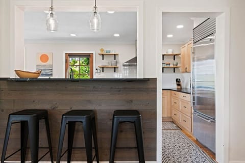 Pass-through from living room to kitchen with bar seating