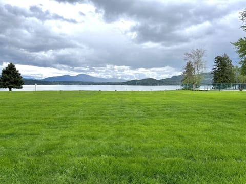 Sprawling lawn near tennis courts, pool and beach.