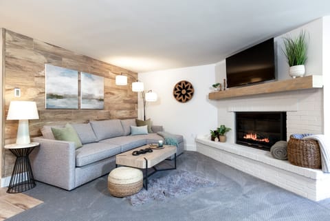 Light, bright living room with a gas fireplace and smart TV to cozy up in.