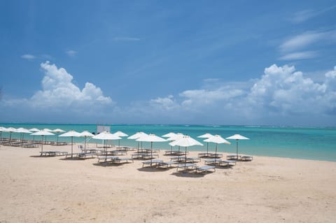 On the beach, white sand, sun loungers, beach umbrellas