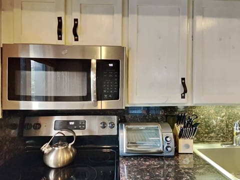A close-up view of the sleek and stylish finishes in the gorgeous kitchen, with its stainless steel appliances and granite countertops and backsplash.
