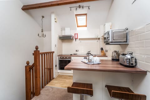 The open plan living and kitchen area has high beamed ceilings and traditional character