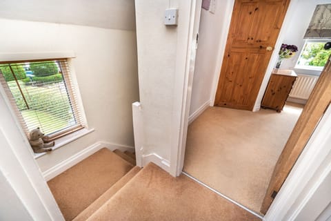 The resident teddy bear sits in the window on the stairs