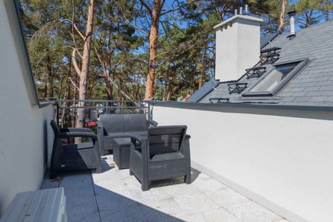 Spacious balcony with outdoor furniture. 