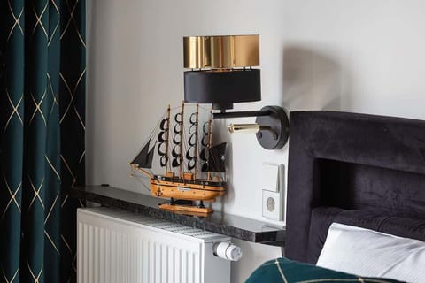 Elegant wall lamp mounted near the bed, providing ambient lighting for evening reading.