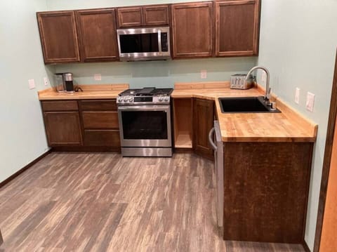 kitchen with gas range, convection oven, microwave oven with outside vent, touchless faucet, garbage disposal, and dishwasher