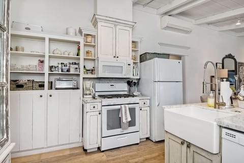 Kitchen view, with gas stove. Lots of dishes.