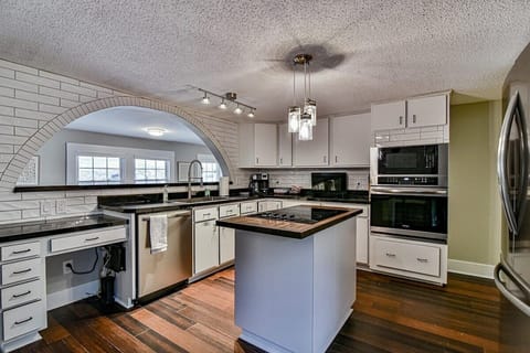 Kitchen with brand new appliances including built in oven and microwave and island cooktop. There's also a desk to the left of the dishwasher perfect for those who need to work or do zoom calls while staying here.