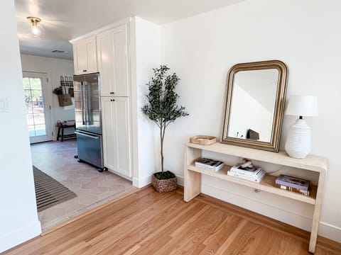 The entryway with fashionable coffee table books flows into the kitchen.