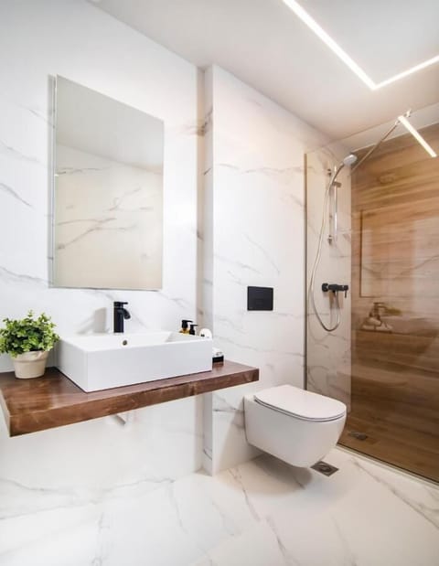 Junior Studio Suite | Bathroom | Shower, rainfall showerhead, hair dryer, slippers