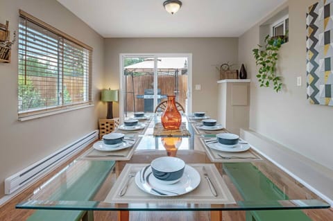 - Gather around this stunning glass top table styled for memorable feasts
- Beautifully set for eight with sleek tableware and a glowing amber centerpiece
- Slide open the doors and fire up the grill for the perfect indoor outdoor meal