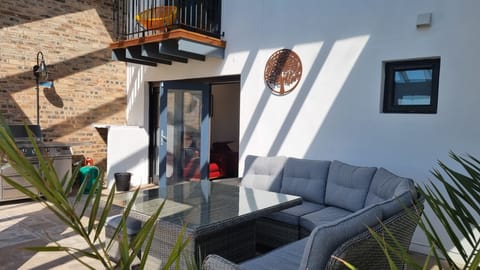 Terrace under the glass roof with dining area and BBQ