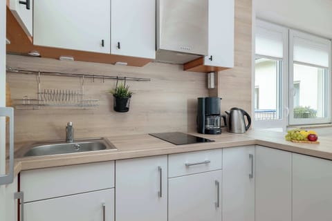 Close-up of the kitchen counter with a coffee maker, kettle, and a few decorations on the shelves.