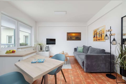 A broader view of the kitchen and living area, showing the open layout with a dining table and a couch.