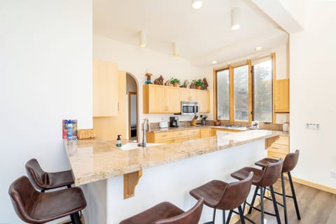 Open kitchen with breakfast bar seating for six