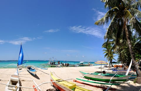 On the beach, white sand, sun loungers, beach umbrellas