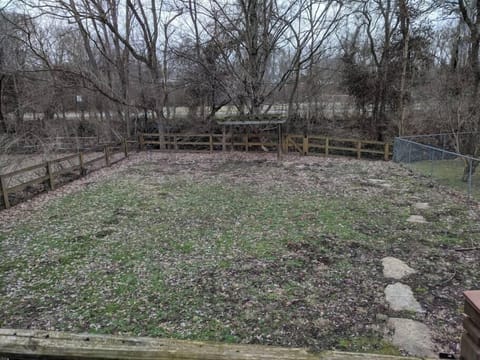Fully fenced back yard with creek running behind . Fence is lined with wire mesh preventing the great dog escape.