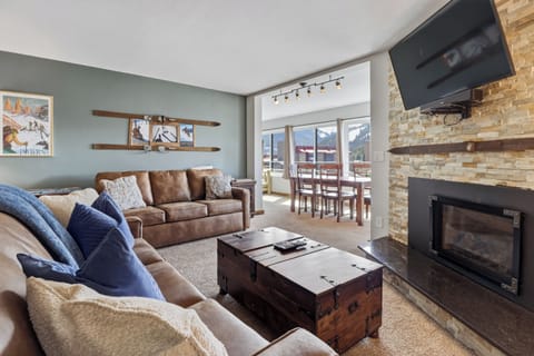 Cozy up in your mountain retreat with leather seating, crackling fireplace, and stunning ski slope views through picture windows.