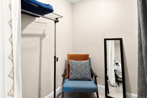 Spacious walk-in closet/storage area with clothing rack and mirror