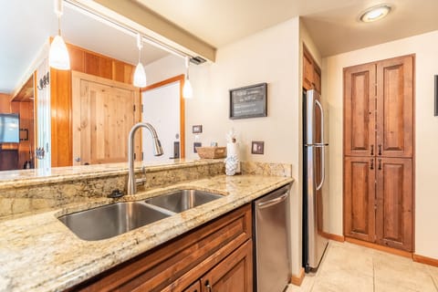 Full size kitchen with stainless steel appliances and granite countertops.