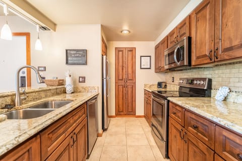 Full size kitchen with stainless steel appliances and granite countertops.