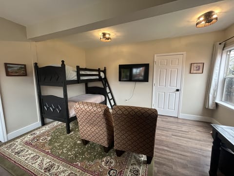 Adjoining room in downstairs of carriage house with bunk beds and TV