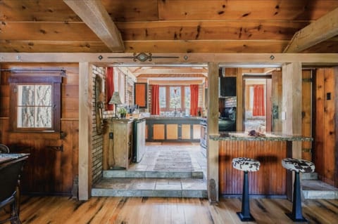 Charming rustic kitchen with warm wooden beams and cozy breakfast bar seating, perfect for enjoying home-cooked meals in a welcoming cabin setting.