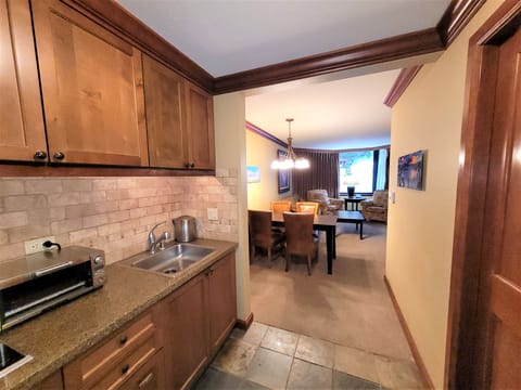 Kitchen with half-fridge, toaster/oven, dishwasher, garbage disposal, stove