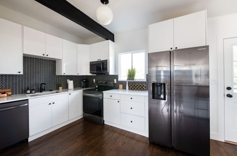 Fully equipped chef's kitchen with stainless appliances and quartz counters.