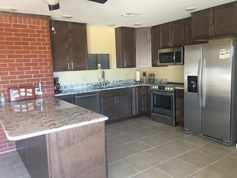 Kitchen fully stocked with utensils.   New refrigerator...has breakfast bar.