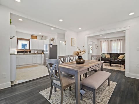Dining area with wood table, bench, and modern chairs - Bright open layout connected to the kitchen and living - Ideal for shared meals with family or friends