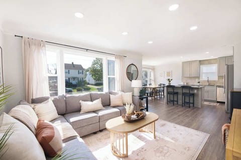 Open living area w/ cozy seating, fireplace & large windows bringing in natural light