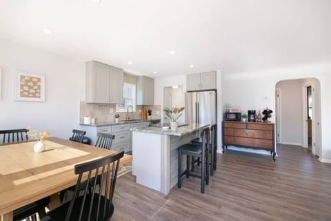 Open-concept living/dining welcomes you at the entry, flowing to a kitchen island. A hall off the kitchen serves two bedrooms and a full bath, with stairs near the front door leading up to a loft and bunk room. 🏠📐🛋️