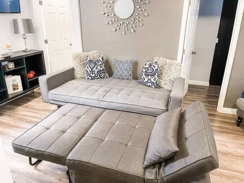 The living room area  includes (1) sofa bed and (1) futon as well as a ROKU Smart TV