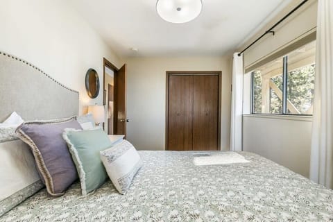 The third bedroom located on the lower level of the home is outfitted with a comfortable queen-size bed and views over the trees.