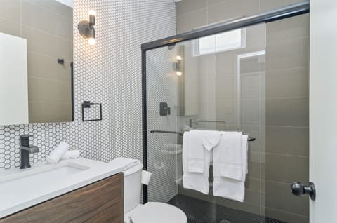 The bathroom has a huge glassed-in shower