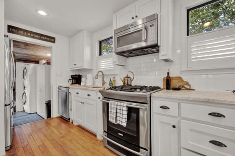 Fully stocked kitchen with stainless appliances - walk through door to backyard