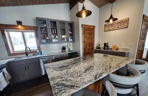 Have a seat at the bar while talking with someone in the kitchen.