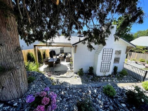 Front of the house with side patio complete with dining table, and sectional with gas fire pit.