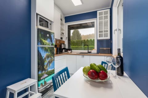 Kitchenette with kettle and refrigerator.