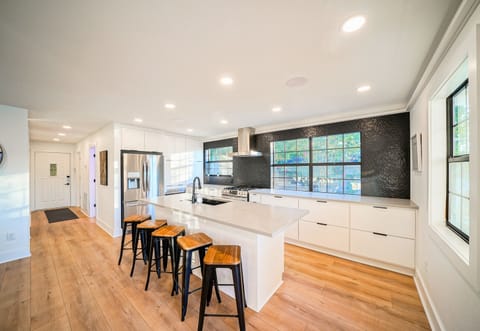 Clean lines and wide-open flow make this kitchen and hallway the heart of the home — stylish, spacious, and ready for group stays.