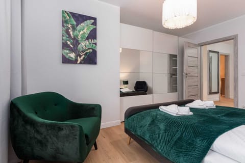 A broader view of the first bedroom, highlighting the natural light and soft bedding.