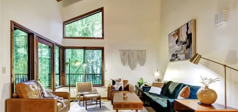 Enjoy the view of the pine trees while relaxing in the stylishly decorated living room with a vaulted ceiling and exposed beams.