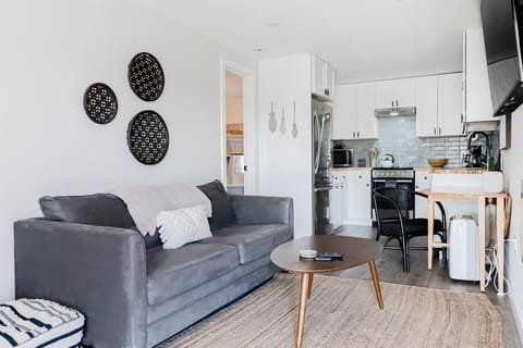 Cozy living room with SmartTV, pull-out couch, and a table to eat or finish some work on.