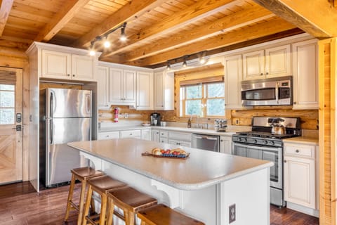 Warm kitchen with modern appliances and barstool seating at the island.